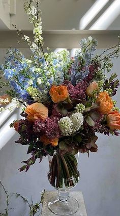 a vase filled with lots of different colored flowers