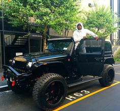 a man standing on top of a black jeep