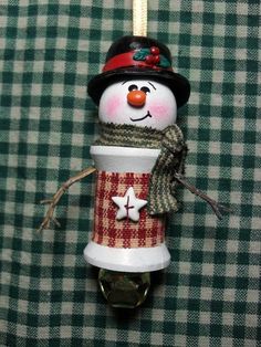 a christmas ornament with a snowman in a top hat and scarf on it