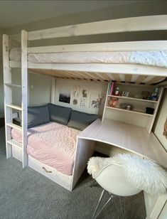 a bunk bed with a desk underneath it in a room that has carpeted flooring