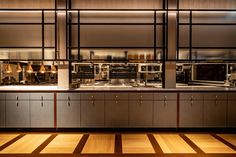 an empty kitchen with stainless steel cabinets and counter tops, along with wooden flooring