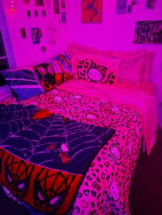 a bed in a room with pink lighting and pictures on the wall