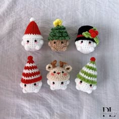 small crocheted gnomes are arranged on a white sheet with red and green hats