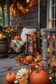 a porch decorated with pumpkins and fall leaves