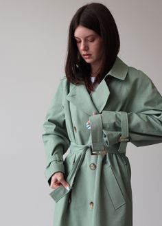 Mint trench coat for women, Relaxed trench coat with belt, Mint long cotton coat, Oversize classic trench coat for fall and spring A classic and timeless trench coat is a great addition to any wardrobe. It has ultimate versatility and pairs well with others. Our cotton mint trench is a slightly oversized classic cut with a vintage touch to it. Perfect for the fall-spring season. ■ color: mint View shop for other color options ■ material: Outer: 100% Cotton Lining: 100% Viscose ■ style: - relaxed Spring Workwear Green Raincoat, Green Spring Workwear Raincoat, Green Spring Raincoat For Work, Oversized Outerwear With Belted Cuffs For Spring, Khaki Long Raincoat For Spring, Belted Long Raincoat For Spring, Spring Gabardine Long Raincoat, Long Cotton Coat, Casual Coats For Women