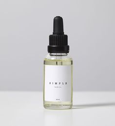 a bottle of hemple essential oil sitting on a white countertop next to a black dropper