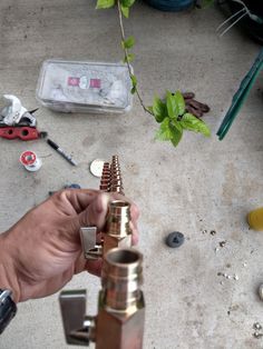 a man is working on some kind of metal thing in his hand and it looks like he's making something out of copper