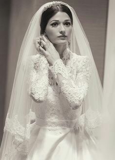 a woman in a wedding dress standing next to a mirror