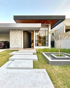 a modern house with concrete steps leading up to the front door