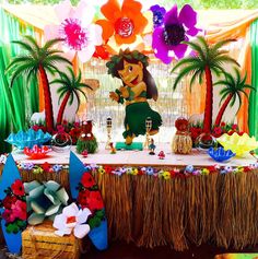 a table topped with lots of paper flowers and plates filled with desserts on top of it