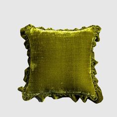 a green velvet pillow with ruffled edges