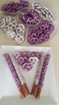 purple and white donuts are arranged in the shape of a v on a plate