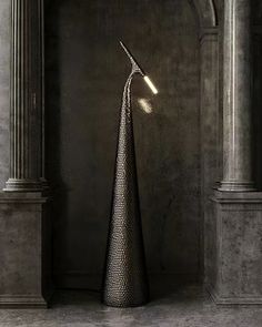 a tall metal sculpture sitting in the middle of a room