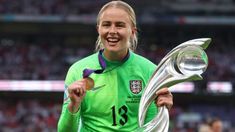 a female soccer player holding up a trophy