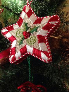 a red and white ornament hanging from a christmas tree