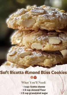 three cookies stacked on top of each other with almonds and powdered sugar in the middle