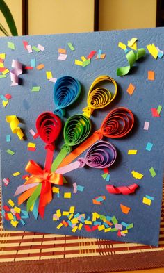 a card with colorful paper flowers and confetti on it