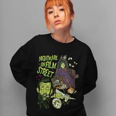 a woman with red hair wearing a black sweatshirt that reads nightmares on film street and features images of characters from various films