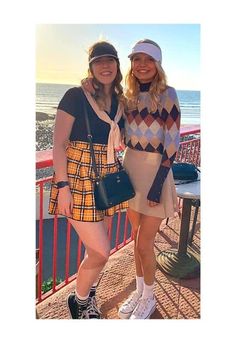 two women standing next to each other near the ocean