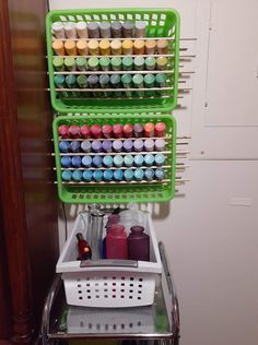 a green rack with two baskets filled with different colored items on top of a metal shelf