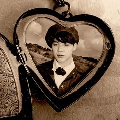 an old photo of a boy wearing a hat and bow tie in a heart shaped frame