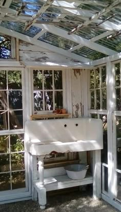 an old white sink sitting under a glass roof