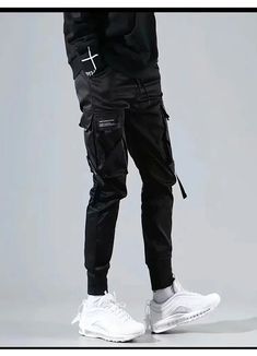 Join the urban expression revolution with our Techwear Cargo Pants. Unveiling the Techwear Joggers, a paragon of avant-garde fashion designed with the audacious urbanite in mind. Picture yourself navigating your city, your silhouette cutting a sharp figure against the concrete jungle. The Techwear Joggers are not just pants; they are a statement of intent, an epitome of edgy street fashion, bringing out the hidden urban warrior within you. These stylish black techwear pants, tailored with a stra Hip Hop Joggers, Streetwear Cargo Pants, Cargo Pants Streetwear, Techwear Pants, Pants Streetwear, Streetwear Pants, Men Trousers, Black Cargo Pants, Japanese Streetwear