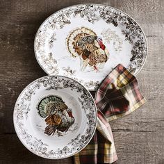 two plates with turkeys on them sitting next to a napkin and plaid napkin holder