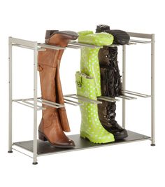 three pairs of boots are sitting on a metal shelf with two shelves holding shoes and one pair of rain boots