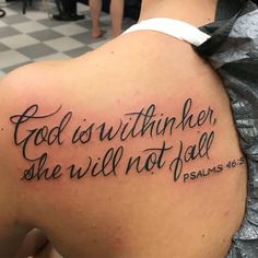 the back of a woman's shoulder with a bible verse tattoo design on it