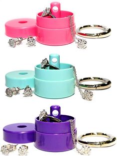 four different colored jewelry containers with rings on them