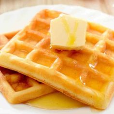 two waffles on a plate with butter and syrup