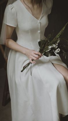 a woman in a white dress holding a bouquet