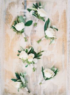 flowers arranged in the shape of a heart on a piece of paper with green leaves