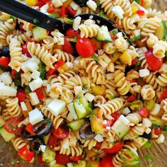 a pasta salad with tomatoes, cucumbers and other vegetables