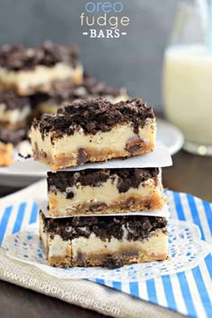 three dessert bars stacked on top of each other with oreo cookies in the background