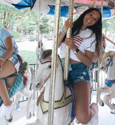 a girl is riding on a merry go round