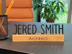 a desk with a name plate and pencils on it