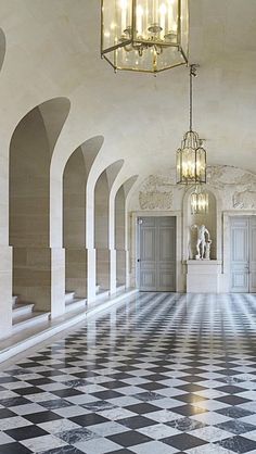 an ornate hallway with chandelier and marble flooring is seen in this image