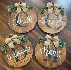 four wooden signs with bows on them that say names and are hanging on the floor