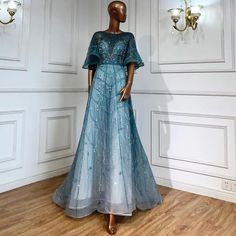 a mannequin wearing a blue dress in front of a white wall with chandeliers