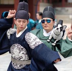 two young men dressed in traditional chinese garb and holding their hands up to the side