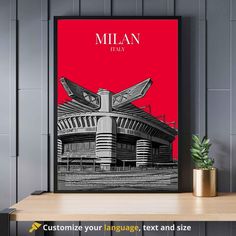 a red and black poster with the name millan stadium on it in front of a wooden table