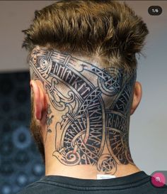 the back of a man's head with tattoos on it