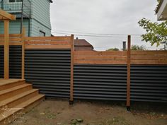 a wooden fence next to a building with stairs