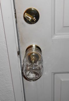 an open door with two glass jars on the front and one in the middle that has a gold handle