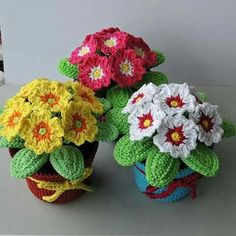 three crocheted flower pots sitting on top of a table