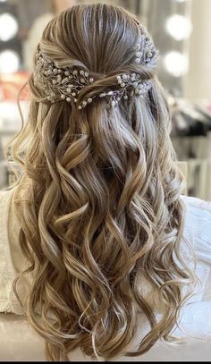 the back of a woman's head with long hair and flowers in her hair