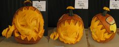 three pumpkins with faces carved to look like cats and dogs, all in different stages of carving