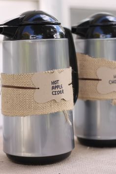 two stainless steel coffee mugs with labels on them